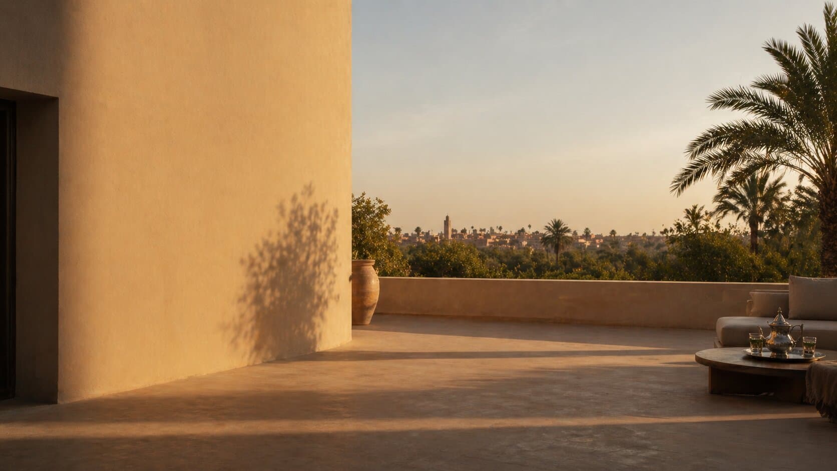 Terrace with palm trees and a view over the Marrakech skyline at sunset